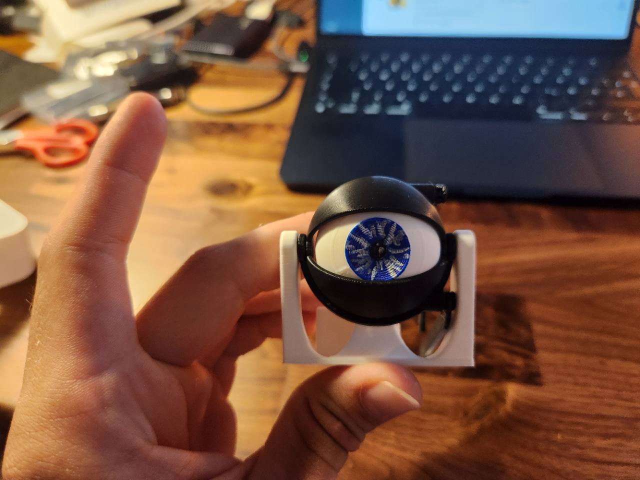 Small assembled 3D-printed eye module held in one hand